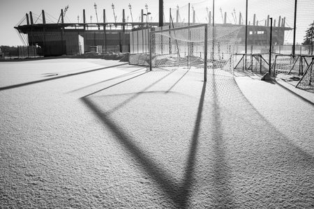 Frozen football pitch covered by snow and stadium in the backgroundの写真素材
