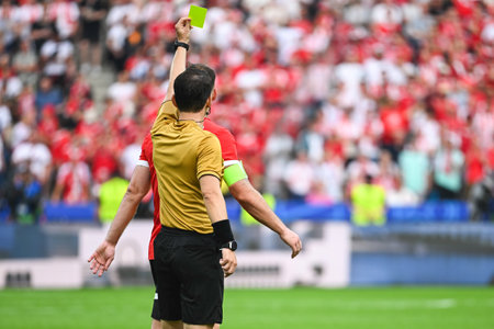 Referee shows yellow card during soccer match at the stadiumの写真素材