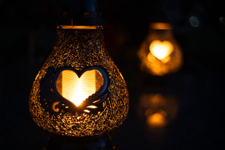 Heart-shaped candles lit on a grave on All Saints' Dayの写真素材