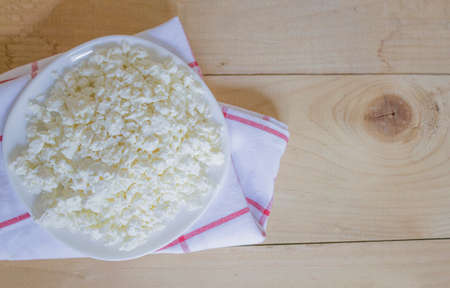 Dish of fresh cottage cheese on a wooden background. Healthly food. Fresh cottage cheese, rustic food. Organic cottage. Keto diet. View from above. Copyspaceの写真素材