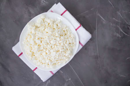 Plate of fresh cottage cheese on a concrete background. Healthly food. Organic cottage cheese. Keto diet. Macro. View from above. Copyspaceの写真素材
