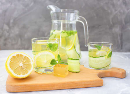 Lemon drink with cucumber and mint. Cooling drink.  Pour a drink into a glassの写真素材