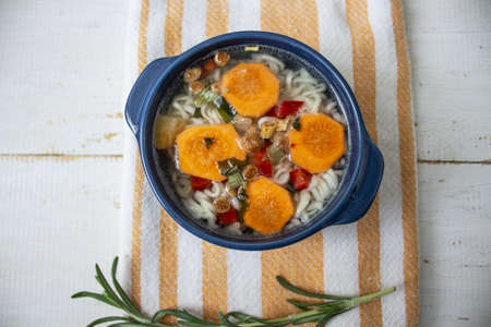 Soup, Vegetable soup, blue pan. Hot soup vegetable soup, carrot on a white background. View from above. Two pots. place for textの写真素材