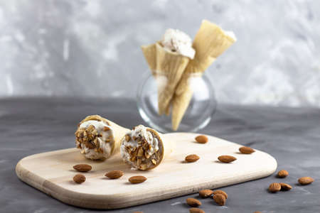 Ice cream background. Fresh ice cream for dessert. Ice cream with almonds on a wooden board. Almond...
