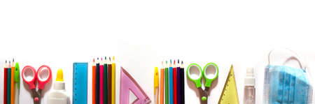 Back to school background concept. School supplies and means of prevention of COVID-19 on a white background. Mask and sanitizer. Banner. copyspaceの写真素材