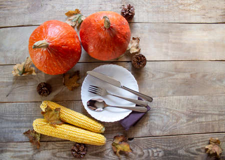 Thanksgiving Dinner. Autumn background of pumpkins and leaves. Cutlery on a festive background. Family dinner. View from above. Copyspaceの写真素材