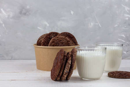 Delicious fresh milk on an old wooden background. A jug of milk and a bottle of milk. Chocolate chip cookies. Eco packaging. copy spaceの写真素材