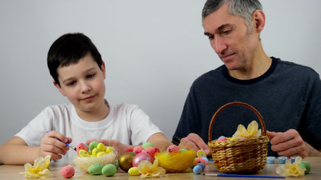 Easter preparation. Dad and son paint eggs. Colorful eggs for easter. 4Kの写真素材