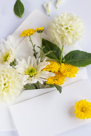 Envelope with flowers. Beautiful flowers in a mail envelope on a white background. greeting card for the holiday. Yellow-blue colors. copy spaceの写真素材