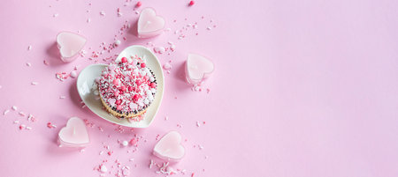 Valentine. Cake on a plate in the shape of a heart on a pink background. Valentine background. Banner.の写真素材
