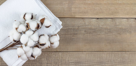 cotton. A white towel and cotton lie on a wooden background. copyspace. Bannerの写真素材