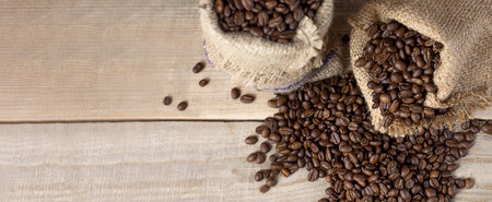 fresh coffee beans. Coffee beans in bags on a wooden background. view from above. copyspace. Bannerの写真素材