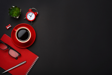 black background red coffee cup note pad alarm clock flowerの写真素材