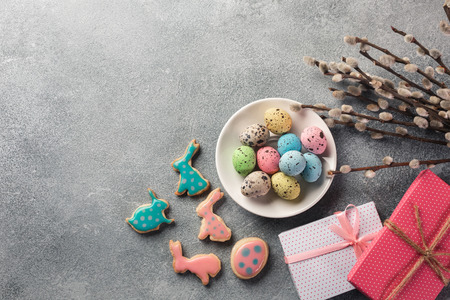 Easter gingerbread cookies with a gift on wooden table. Rabbits and eggs. Greeting card. Top view...