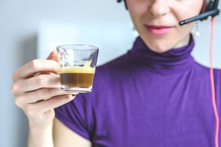 detail of espresso cup in the hands of a female office worker