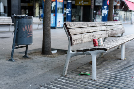 Sabadell, SPAIN - 06/24/2020: garbage on a bench near a paper binのeditorial素材