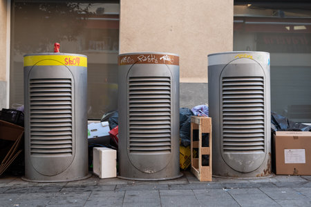 Sabadell, SPAIN - 06/24/2020: trash on the ground around waste containers at Sant Roc squareのeditorial素材