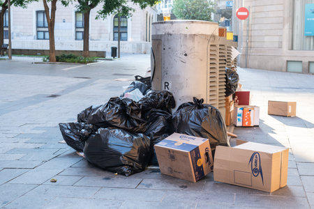 Sabadell, SPAIN - 06/24/2020: trash on the ground around waste containers at Sant Roc squareのeditorial素材