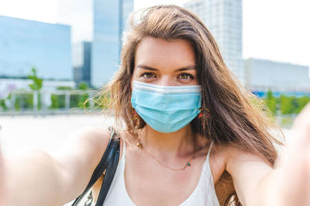 self picture taken by a young woman wearing surgical blue maskの写真素材