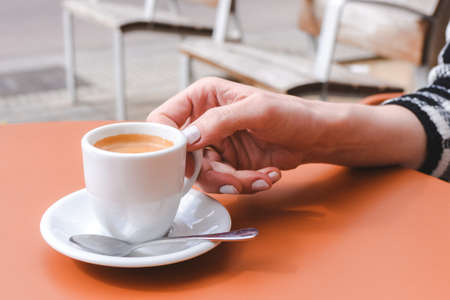 unrecognizable caucasian woman enjoying espresso coffee on a cafe terraceの写真素材