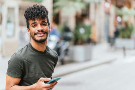 Latin handsome man in the street looking at camera and smilingの写真素材