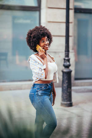 vertical portrait of an african woman captured while talking by phone