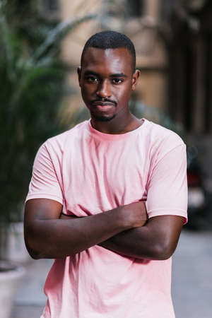 portrait of an african young man crossing his arms and looking at camera