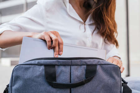 Unrecognizable indian woman taking laptop out of the bagの写真素材