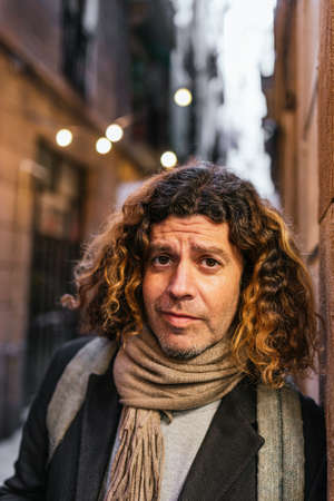 Mature man leaning on wall on streetの写真素材