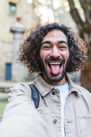 Cheerful man taking selfie on street