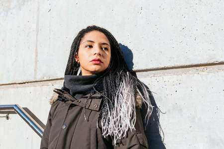 Calm woman with braids in cityの写真素材