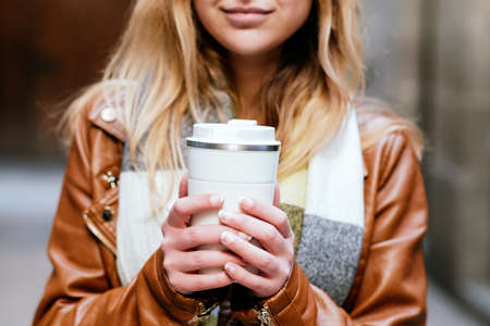 Unrecognizable woman with takeaway coffee
