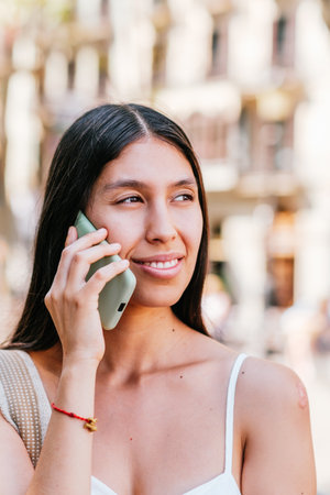 Latin American woman answering phone callの写真素材