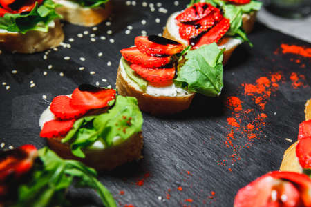 snacks with meat and vegetables. Tapas with strawberries and cheese. Prosciutto with pears and arugula.の写真素材