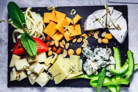 snacks with meat and vegetables. The set of cheese.Tapas with strawberries and cheese, salmon with pickled cucumber. Prosciutto with pears and arugula.の写真素材