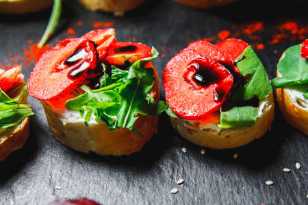 snacks with meat and vegetables. Tapas with strawberries and cheese. Prosciutto with pears and arugula.の写真素材