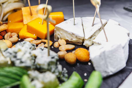 snacks with meat and vegetables. The set of cheese.Tapas with strawberries and cheese, salmon with pickled cucumber. Prosciutto with pears and arugula.の写真素材