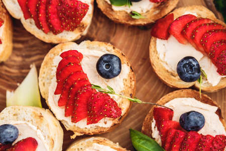 snacks with berries and vegetables. The set of cheese.Tapas with strawberries and cheese. Prosciutto with pears and arugulaの写真素材