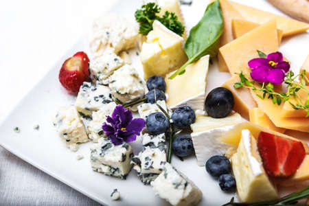 snacks with berries and vegetables. The set of cheese.Tapas with strawberries and cheese. Prosciutto with pears and arugulaの写真素材