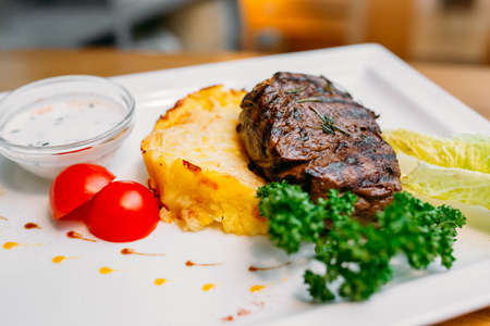 European international fusion cuisine, a beautiful dish on a white plate decorated with herbs and vegetables. a professional chef has prepared a delicious meal. Vegetarian food and meat restaurant dishes. fast food.の写真素材