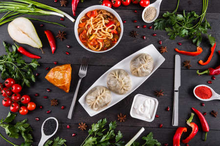The concept of Eastern asian festive cuisine. Assorted Uzbek food set, pilaf, samsa, lagman, manta, shurpa restaurant concept, Uzbek food. Homemade Eastern arabic new year and Christmas dish from lamb served in cast iron cookware.の写真素材