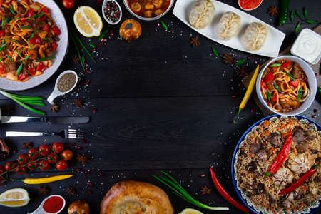 The concept of middle East cuisine. Assorted Uzbek food set, pilaf, samsa, lagman, manti, shurpa eastern restaurant concept, Uzbek food. pilaf or plov from lamb served in cast iron cookware.の写真素材