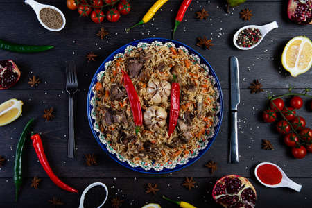 The concept of oriental cuisine. Assorted Uzbek food set, pilaf, samsa, lagman, manta, shurpa Uzbek restaurant concept, Uzbek food. Homemade Uzbek pilaf or plov from lamb served in cast iron cookwareの写真素材