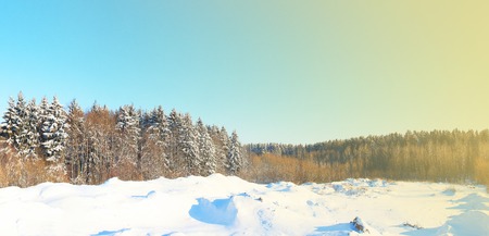 Winter sunny day on a background of forest and hills, covered with snow. Side shines a ray of sunshine. Landscape winter nature. Prekrsny day in the wild. Place for winter sports and hiking.の写真素材