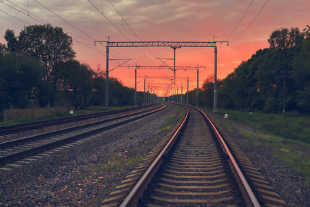 Railway tracks at the railway station in the evening at sunset the rails and sleepers for the movement of trains.の写真素材