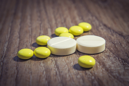 Pills Tablets on table close up. Pharmaceuticals, chemistry, medicine. Treat disease with pills. course of treatment.の写真素材