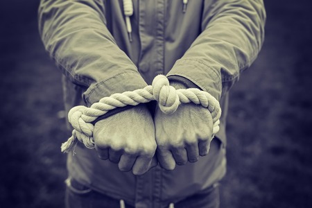 Human hands tied with rope closeup. The concept of human rights and violenceの写真素材