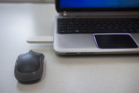 Desktop with modern notebook, optical mouse and 4g modem connected in usb port of laptop.の写真素材