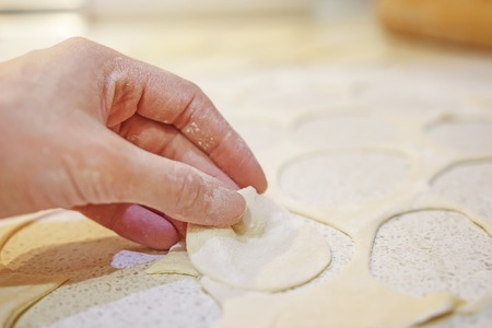 Close-up of hand with dough on background of table with flour. Bake bread. Baking of bakery products.の写真素材