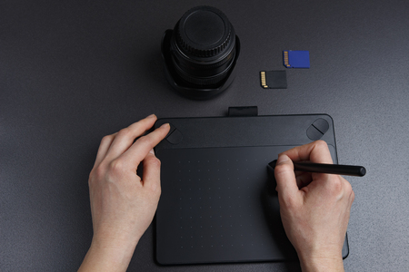 photographer processes photos on graphic tablet with pen. The artist's workbench is  photographer.の写真素材